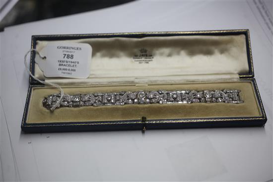 An attractive 1930s/1940s Art Deco white gold and diamond encrusted bracelet in Jays of London fitted box, 7in.